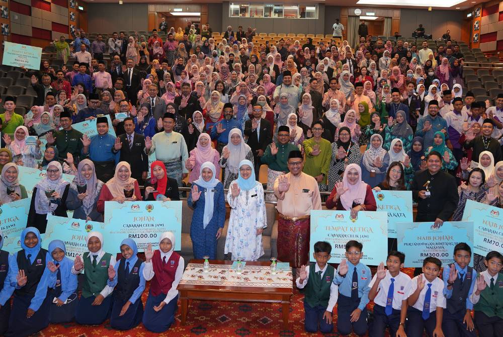 Rusmini (tengah) bergambar kenangan bersama pemenang dan peserta pertandingan yang dianjurkan sempena Karnival Bahasa Kebangsaan KPM 2024 di Auditorium Kompleks E, Putrajaya. 