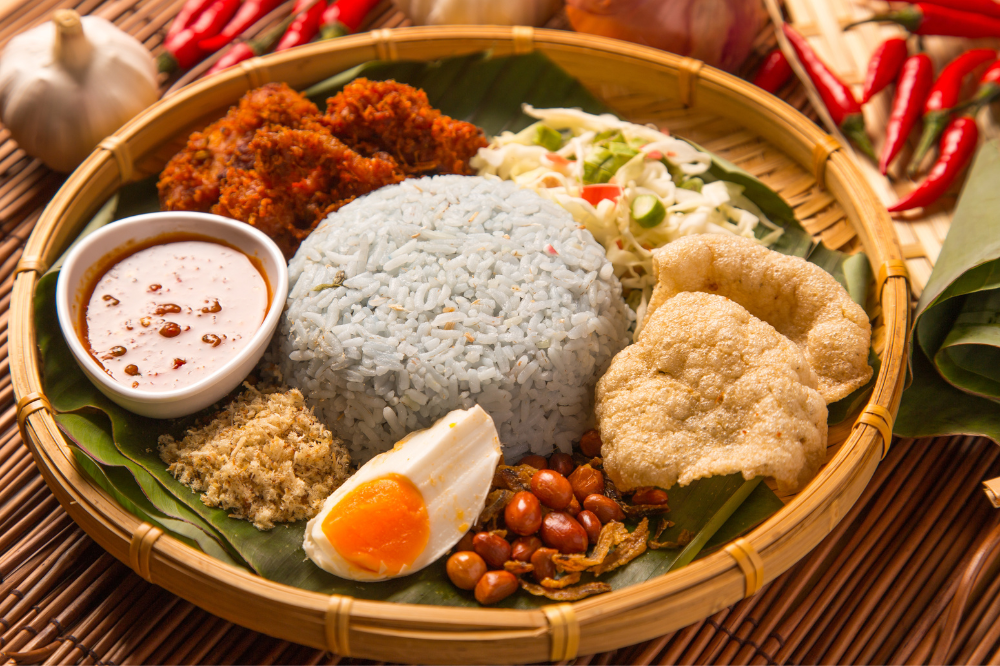 NASI Kerabu通常配有蓝色鲜艳的米饭，以及各种Ulam（生草药和蔬菜），炸咸鱼，鱼饼干（Keropok Ikan）等。照片：123rf