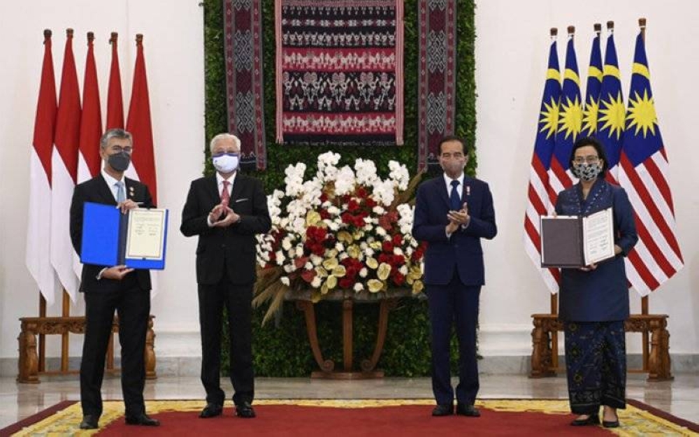 Ismail Sabri bersama Jokowi menyaksikan Menteri Kewangan, Tengku Datuk Seri Zafrul Abdul Aziz menunjukkan dokumen bersama Menteri Kewangan Indonesia, Sri Mulyani Indrawati selepas menandatangani perjanjian di Istana Bogor. - Foto Bernama