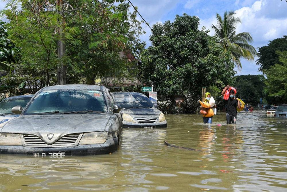 Mangsa-mangsa banjir di Taman Seri Muda Seksyen 25 mengambil barang keperluan berikutan banjir yang masih belum surut sepenuhnya pada Selasa. - Foto Bernama