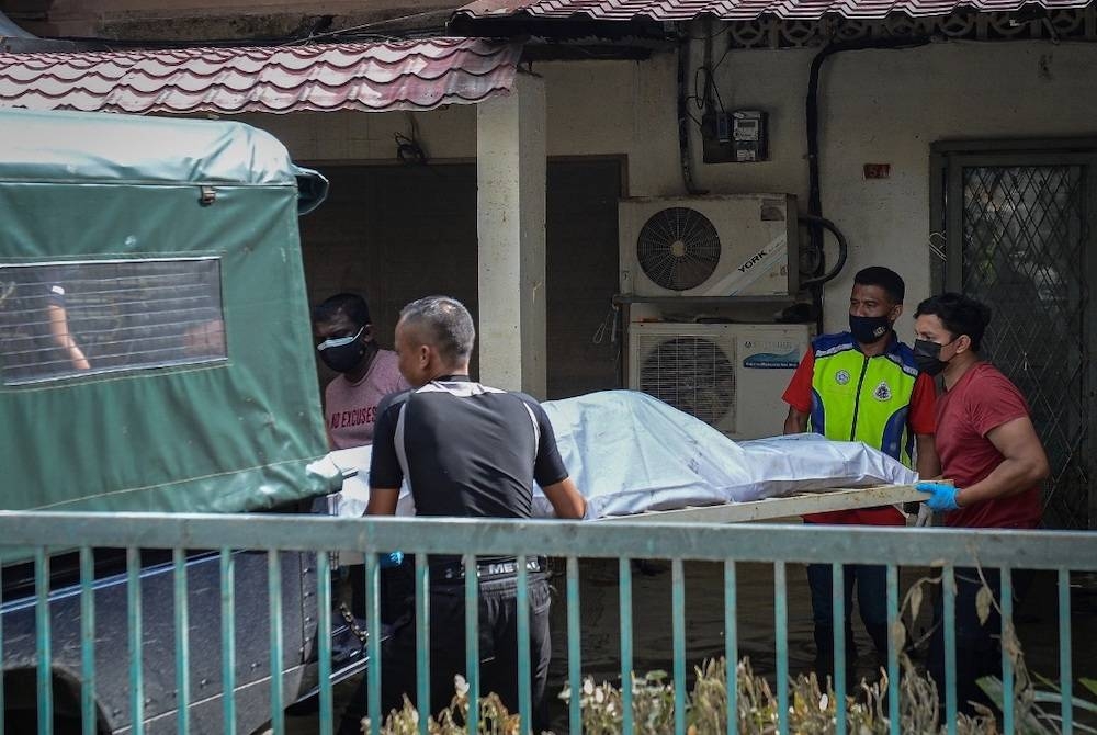 Anggota polis membawa keluar dua mayat yang dijumpai di sebuah rumah Taman Sri Muda dipercayai lemas akibat banjir pada Rabu. - Foto Bernama