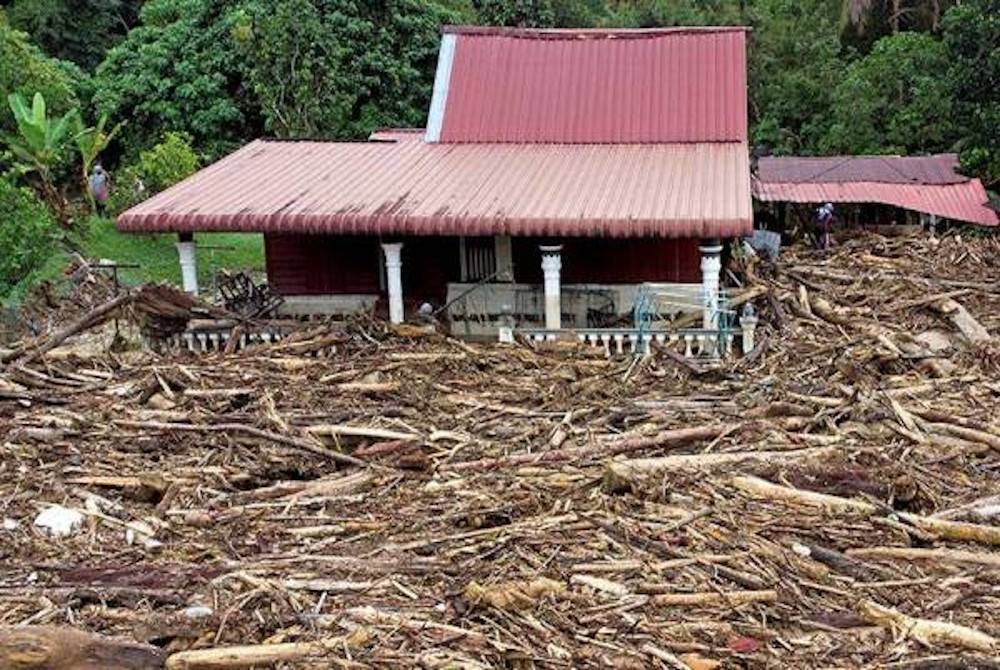 Keadaan persekitaran laman sebuah rumah di Batu 7 Kampung Pantai yang dipenuhi timbunan kayu dan pokok besar akibat dihanyutkan arus banjir malam tadi.- Foto Bernama