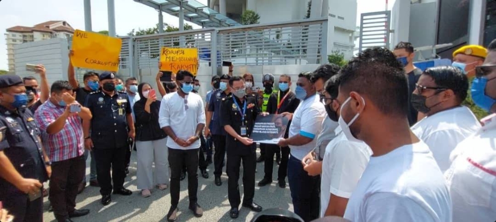 Naib Ketua Angkatan Muda Keadilan (AMK), Thiban Subbramaniam menyerahkan memorandum dalam bentuk plakad kepada pegawai Suruhanjaya Pencegahan Rasuah Malaysia (SPRM) sewaktu majlis konvoi protes ‘Selamatkan SPRM’ dari Dataran Putrajaya ke Ibu Pejabat SPRM pada Isnin.