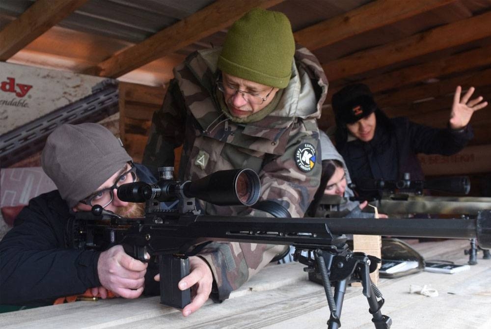 Orang awam menyertai latihan menembak di sebuah kompleks lapang sasar di luar bandar Lviv sebagai persediaan menghadapi ancaman tentera Rusia.