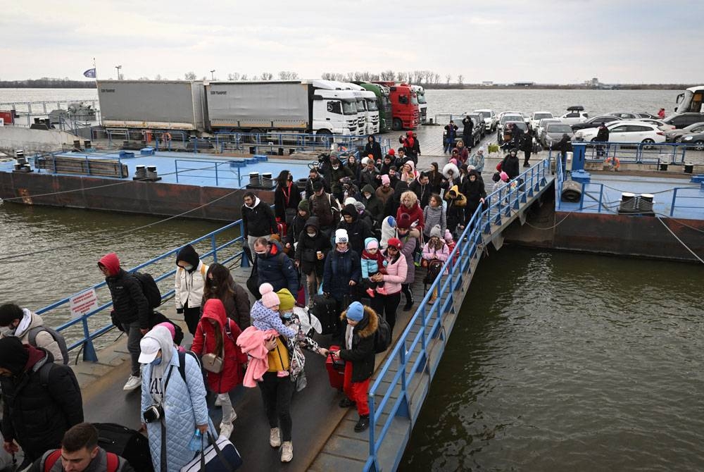 Kumpulan pelarian Ukraine menaiki feri ketika menyeberangi Sungai Danube di lintasan sempadan Isaccea-Orlivka antara Kiev-Bucharest.