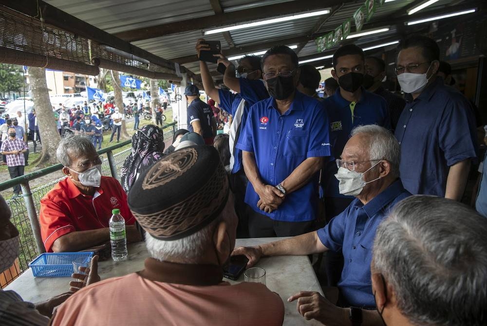 Najib (duduk, dua dari kanan) ketika bersama calon BN Dewan Undangan Negeri (DUN) Kempas, Datuk Ramlee Bohani (berdiri tiga, kanan) meluangkan masa bersarapan bersama penduduk sempena kempen Pilihan Raya Negeri (PRN) Johor di Taman Cempaka, Kempas baru-baru ini. - Foto Bernama