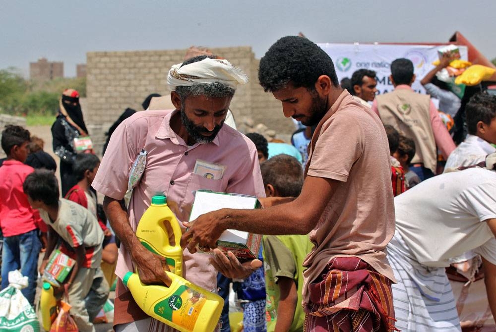 Penduduk Yemen yang terjejas konflik itu menerima bekalan makanan yang diedarkan di wilayah Hodeida.