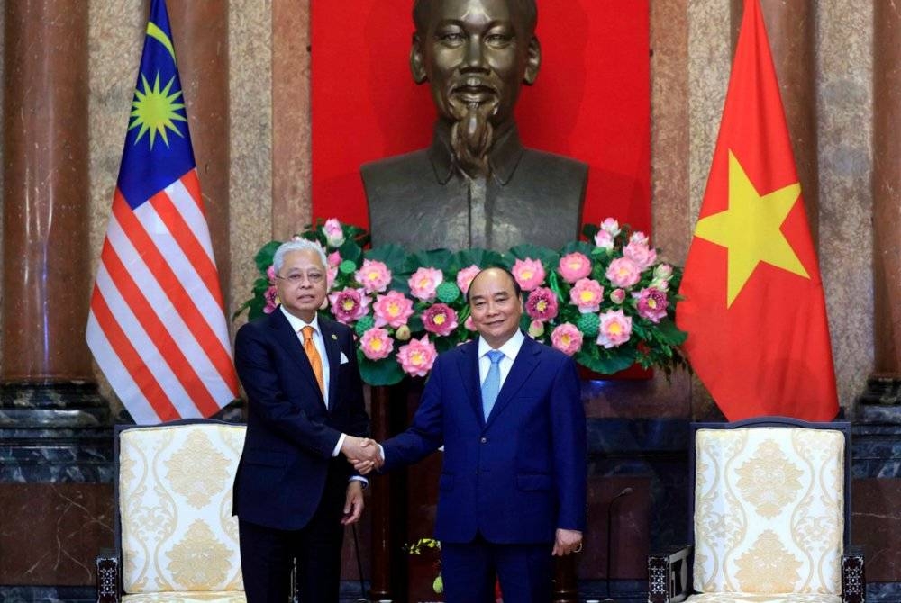  Ismail Sabri (kiri) bersalaman dengan Nguyen Xuan Phuc ketika kunjungan hormat ke atas Presiden Vietnam di Istana Presiden. - Foto Bernama
