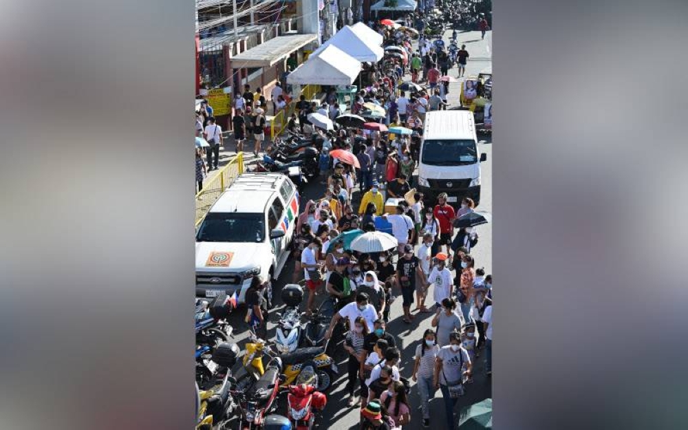 Orang ramai sanggup beratur panjang walaupun dalam keadaan cuaca panas di Quezon City, pinggir Manila.