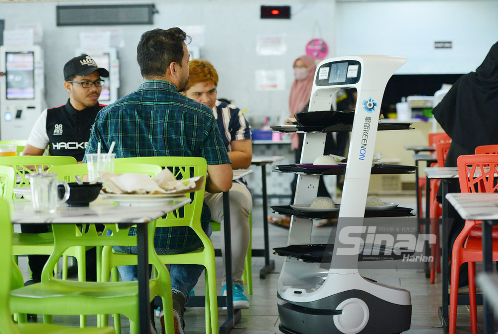 Tugas menghantar makanan atau minuman diambil oleh robot-robot sekali gus mengurangkan kebergantungan kepada pekerja. - FOTO MOHD HALIM ABDUL WAHID