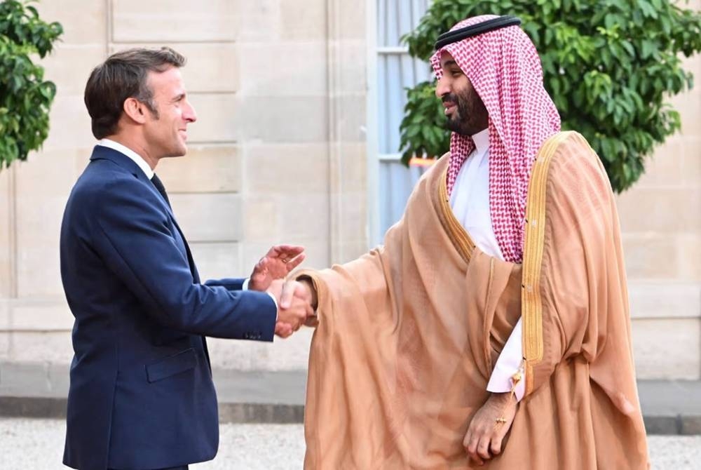 MBS (kanan) berjabat tangan dengan Macron ketika kedua-duanya mengadakan pertemuan di Paris baru-baru ini. - AFP