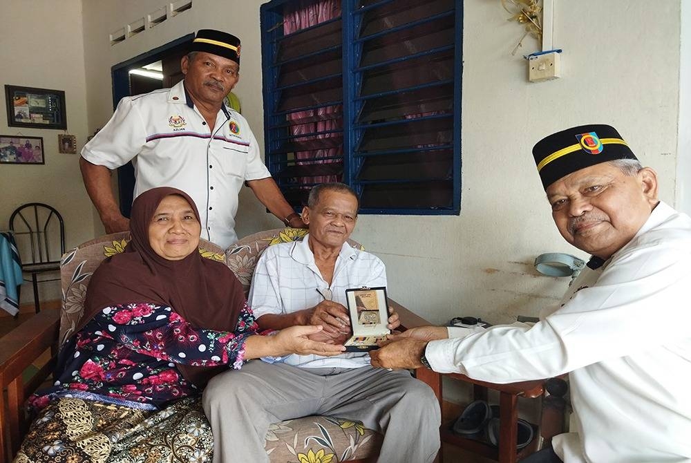 
Nonasi dan isteri bergambar bersama ahli Persatuan Veteran ATM Johor yang datang menziarah beliau di rumahnya di Kluang, Johor, baru-baru ini.