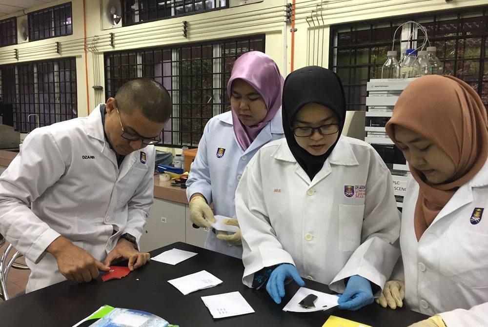 Pelajar Program Kimia Analisis Forensik UiTM Shah Alam sedang menjalankan analisis cat di makmal universiti.