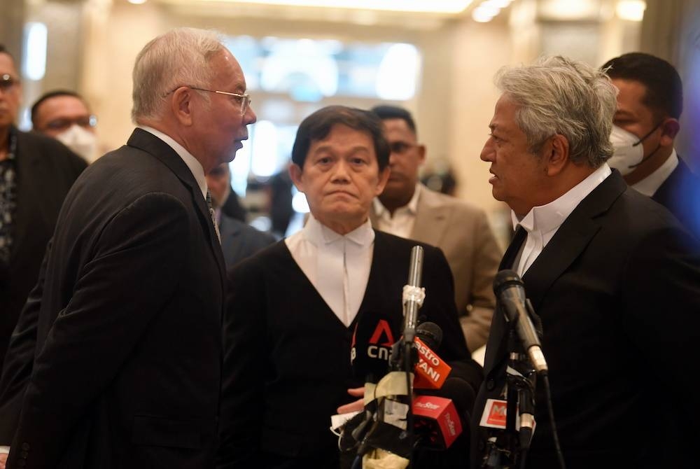 Najib (kiri) berbincang bersama peguamnya Hisyam (tengah) dan Zaid (kanan) selepas sidang media di Mahkamah Persekutuan.