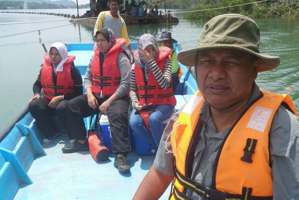 Mohamad Pauzi Zakaria (kanan) bersama pelajar-pelajar mendapatkan sampel air di salah sebuah di Sungai Kemaman, Terengganu.