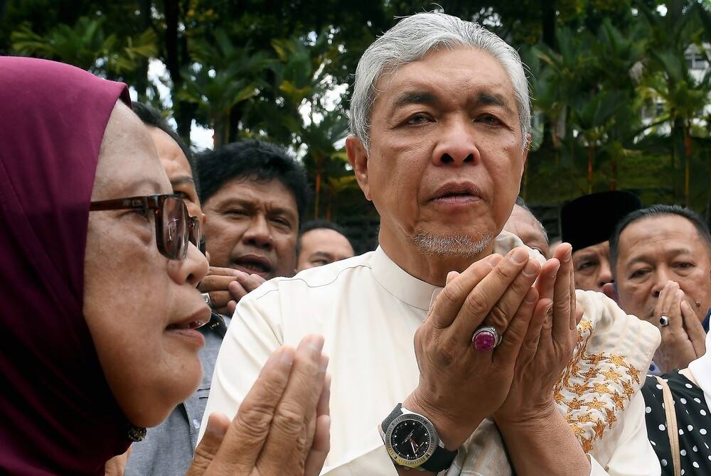 Bekas Timbalan Perdana Menteri, Datuk Seri Dr Ahmad Zahid Hamidi (kanan) mengaminkan doa bersama penyokong yang hadir di luar perkarangan Kompleks Mahkamah Shah Alam pada Jumaat. - Foto Bernama