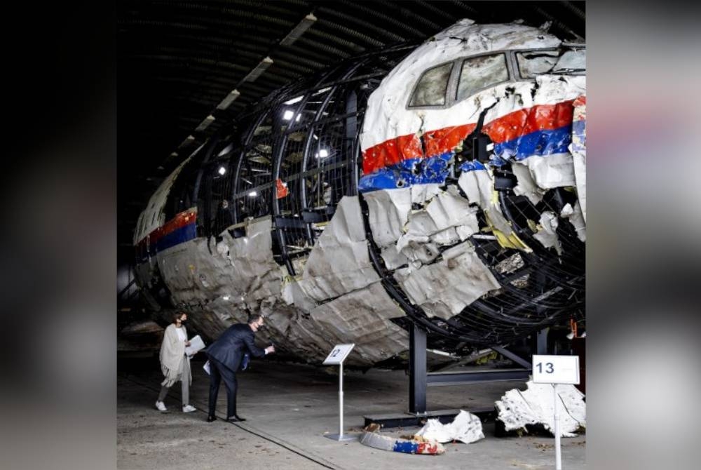 Wakil panel hakim memeriksa bangkai pesawat MH17 yang dibina semula di pangkalan tentera Gilze-Rijen selatan Belanda pada Mei 2021.