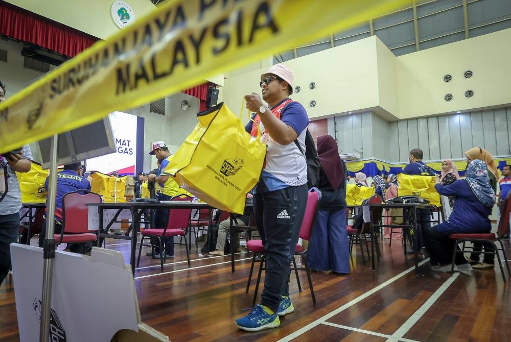 Petugas Suruhanjaya Pilihan Raya kelihatan membawa peti undi semasa melakukan persiapan akhir menjelang PRU15 di Pusat Penjumlahan Rasmi Undi PRU15 Parlimen Putrajaya pada Jumaat. - Foto Bernama