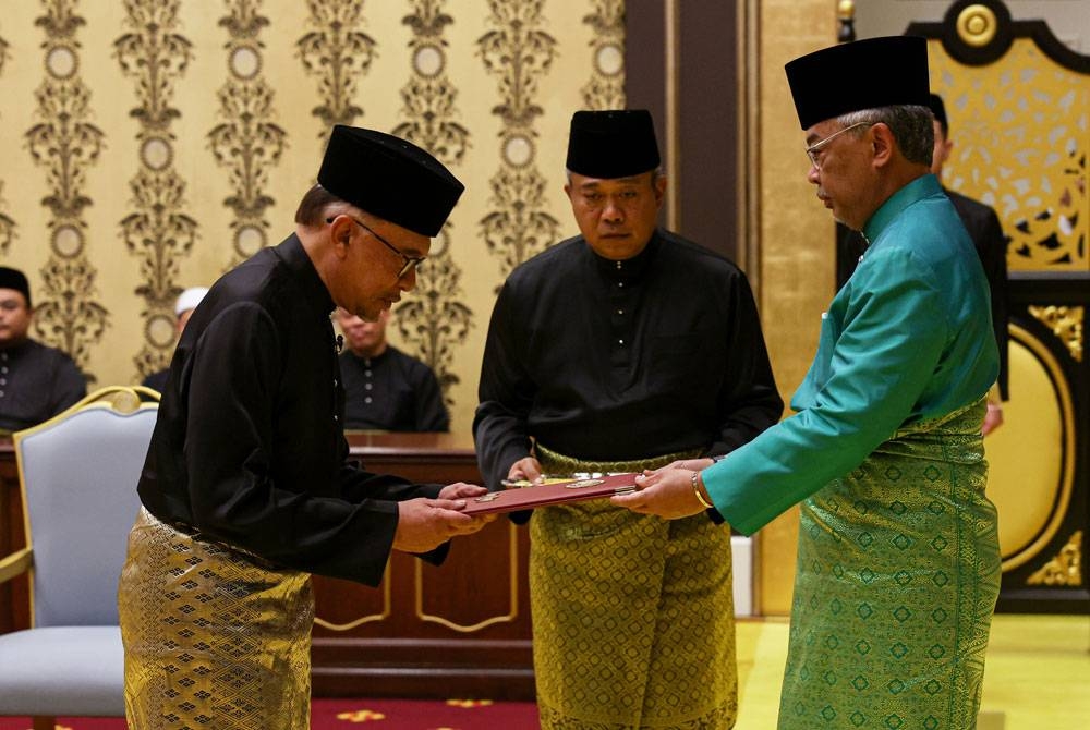 Al-Sultan Abdullah (kanan) berkenan menyampaikan Surat Cara Pelantikan dan Mengangkat Sumpah Jawatan dan Setia serta Sumpah Simpan Rahsia kepada Anwar pada Istiadat Pengurniaan sebagai Perdana Menteri ke-10 di Istana Negara pada Khamis. - Foto Bernama