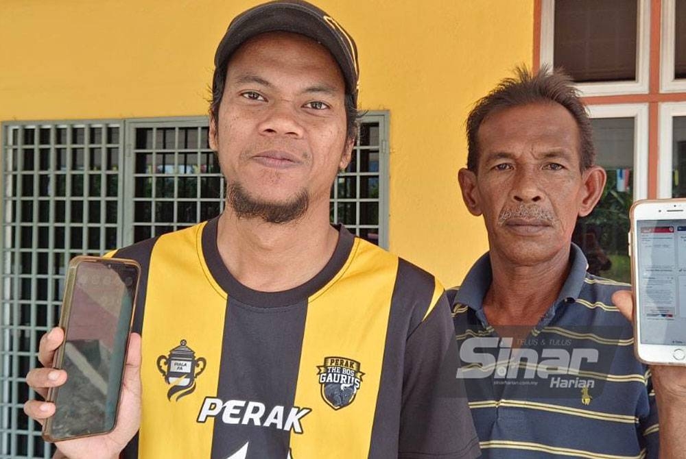 Norazman (kanan) dan Afiq Wazien Abd Halim menunjukkan capaian internet yang lemah di Kampung Batu 4, Segari, Manjung.