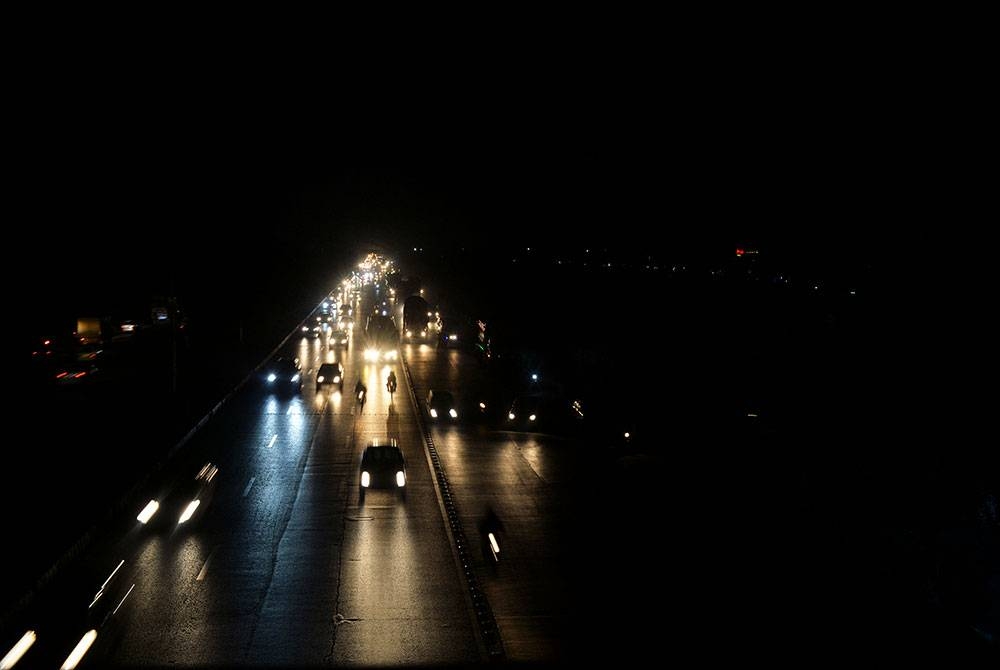 Pemandangan jalan raya di sekitar Islamabad tanpa lampu tiang akibat gangguan bekalan elektrik. - Foto AFP