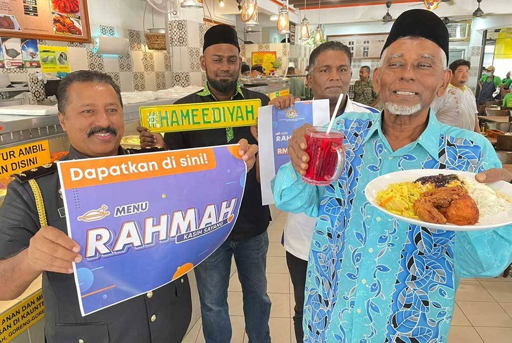 Pengurus Restoran Hameediyah Sungai Ara, Muhamad Salim Ahamed Seeni Pakir (dua dari kiri) menunjukkan salah satu menu yang akan disediakan dalam Menu Rahmah yang akan dilancarkan pada 1 Mac nanti.