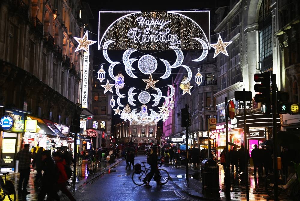 Piccadily Circus bergemerlapan dengan lampu bulan sabit dan bintang beraneka saiz dan warna, melatari ucapan ‘Happy Ramadan’. - Foto EPA