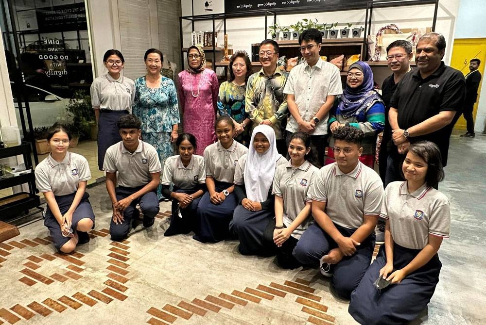 Penulis (empat dari kanan) bergambar kenangan ketika menyertai majlis berbuka puasa di kafe yang dikendalikan oleh Dignity for Children Foundation.