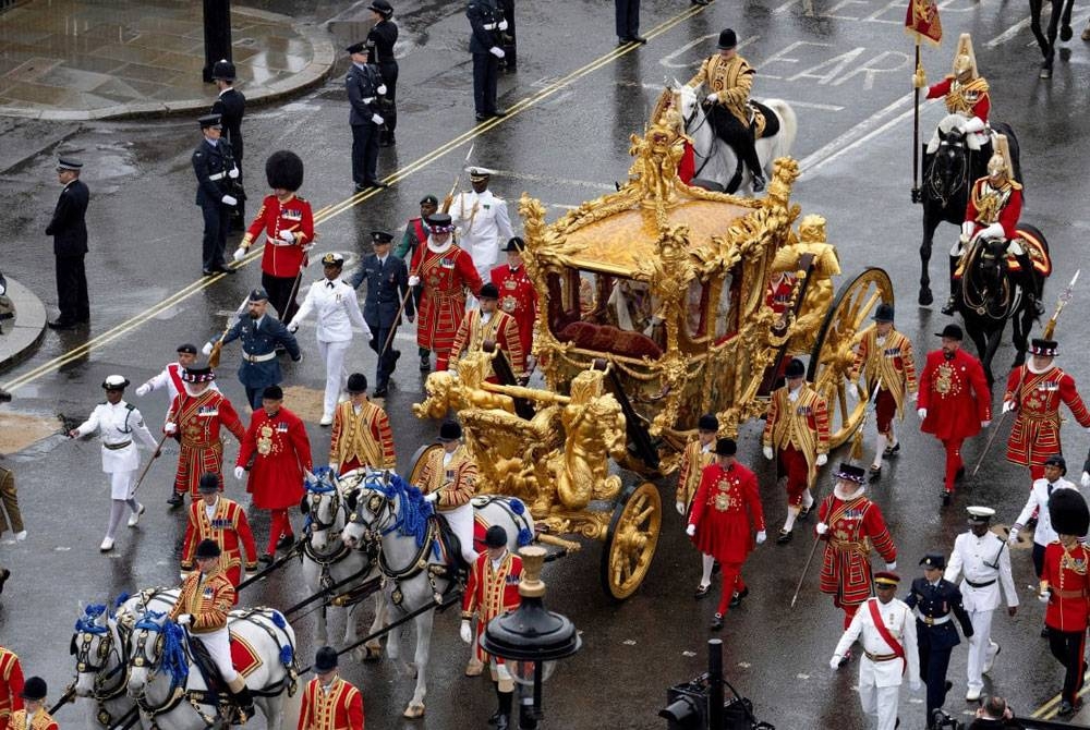 Raja Charles III dan Permaisuri Camilla dibawa menaiki kereta kuda Gold State Coach. - Foto Reuters