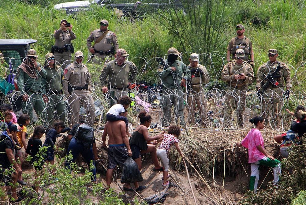 Pasukan keselamatan menyaksikan kumpulan pendatang cuba memasuki AS selepas menyeberangi Sungai Rio Grande di Matamoros.