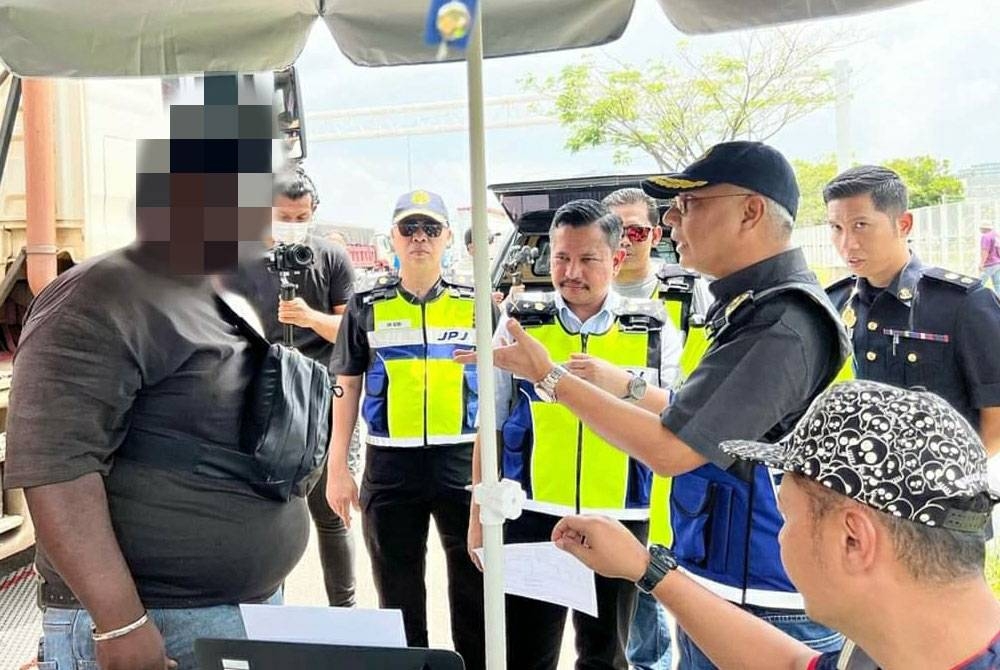 Lokman (dua dari kanan) sedang menyoal siasat salah seorang pemandu lori dalam Ops Mammoth yang dilaksanakan di Kuantan, Pahang pada Khamis.