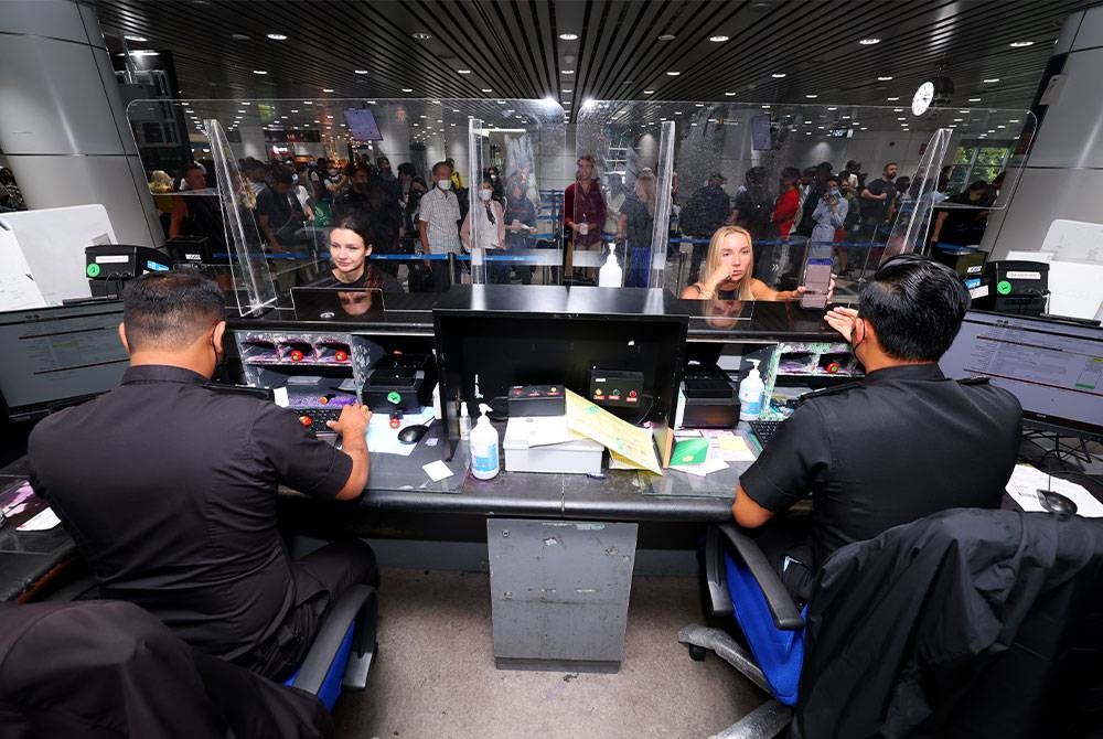 Petugas Jabatan Imigresen Malaysia memeriksa pasport pelancong asing di pintu masuk negara di Lapangan Terbang Antarabangsa Kuala Lumpur (KLIA). (Gambar hiasan) - Foto Bernama