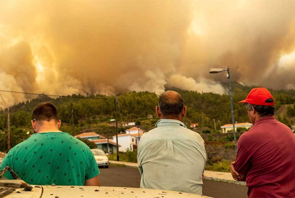 Penduduk menyaksikan kebakaran hutan yang melanda kawasan peranginan di La Palma.