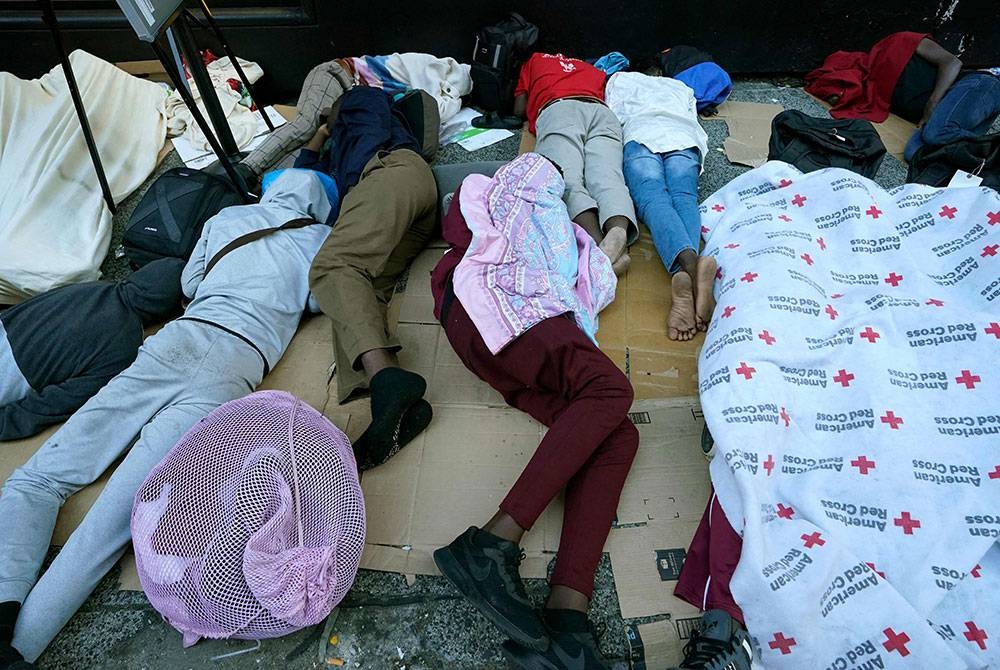 Kaki lima menjadi tempat tidur sementara pencari suaka apabila hotel untuk menempatkan migran di New York City beroperasi pada kapasiti hampir 100 peratus. - Foto AFP