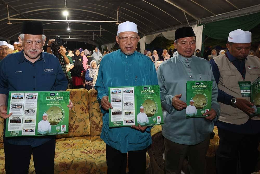 Timbalan Mursyidul Am Pas, Datuk Ahmad Yakob (dua, kiri) memegang buku Manifesto sempena Pelancaran Program Manifesto Pilihan Raya Umum Perikatan Nasional (PN) negeri Kelantan di Dataran Majlis Daerah Tanah Merah pada Isnin. - Foto Bernama