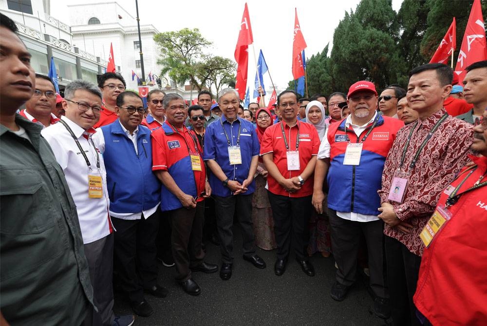 Presiden BN, Datuk Seri Dr Ahmad Zahid Hamidi turut berarak bersama calon PH, Suhaizan Kaiat bagi Parlimen Pulai menuju ke Pusat Penamaan Calon Dewan Jubli Intan Sultan Ibrahim pada Sabtu. - Foto Bernama