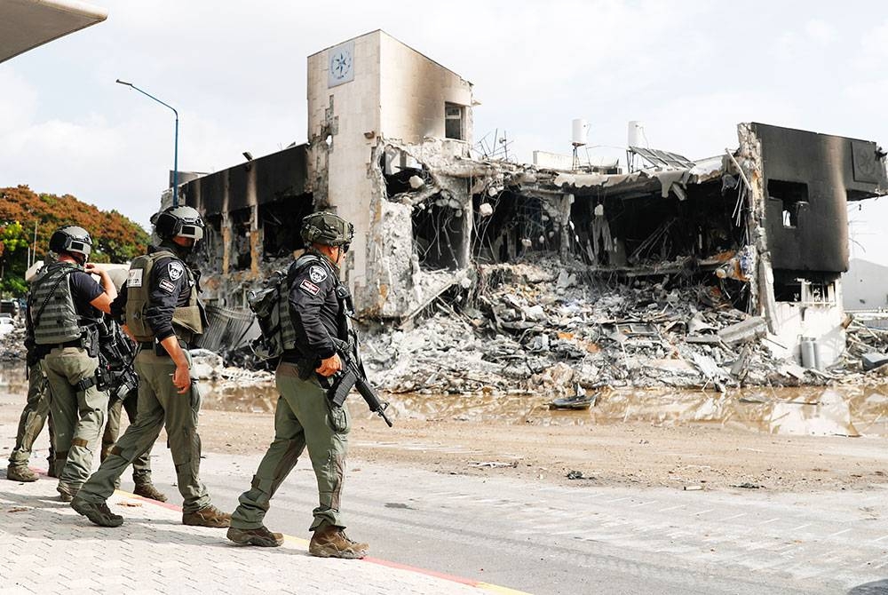 Tentera Zionis berkawal di hadapan balai polis yang dimusnahkan pejuang Hamas di Sderot, sempadan Gaza pada Ahad. - Foto EPA