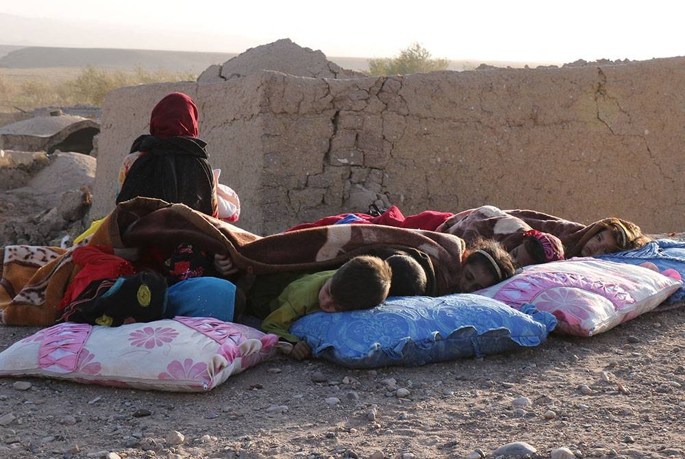 Kanak-kanak Afghanistan berehat di kawasan terbuka bersebelahan rumah mereka yang ranap di perkampungan Sarbuland, wilayah Herat. - Foto AFP