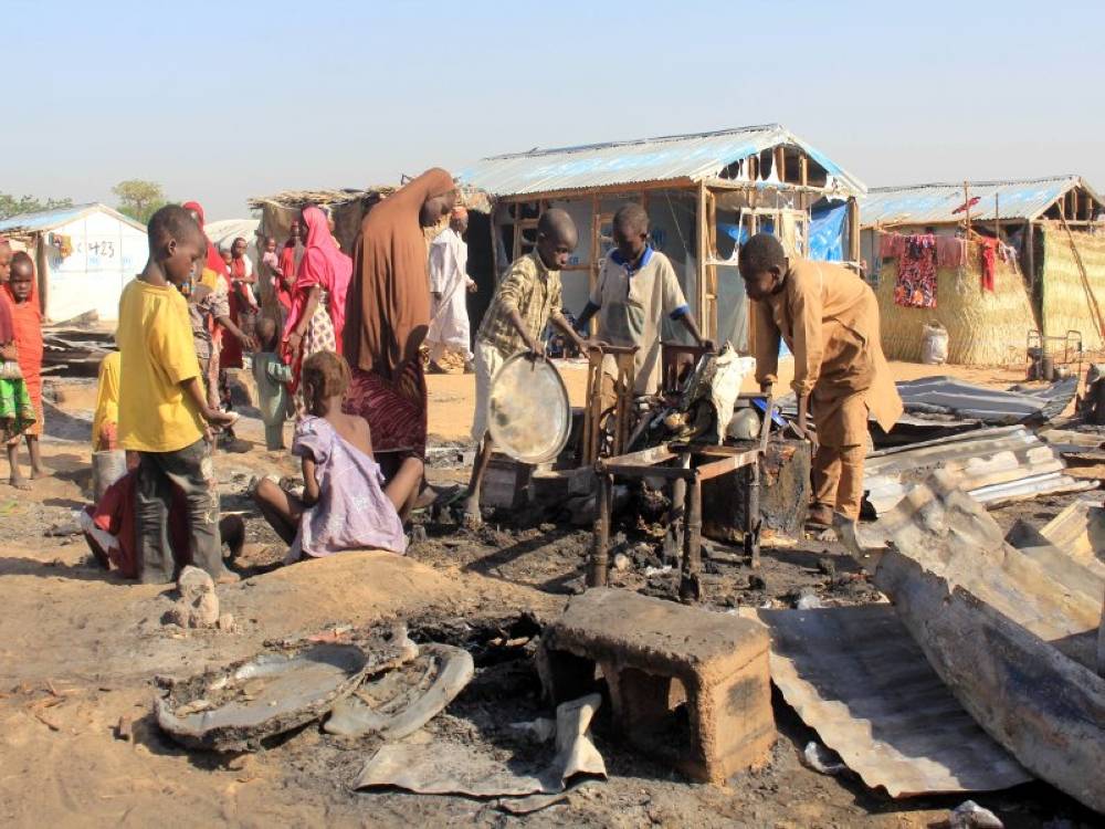 Penduduk melihat rumah yang dibakar militan Boko Haram di Dalori, Nigeria pada 1 November 2018. - Gambar Fail AFP