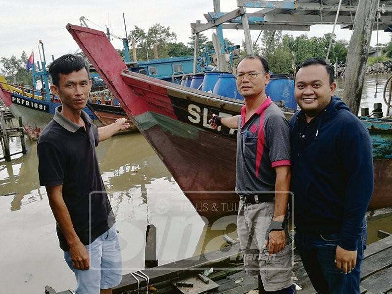 Dari kanan; Hairul, Pang Long dan Ah Siong menunjukkan bot pukat tunda yang memerlukan jeti sementara.