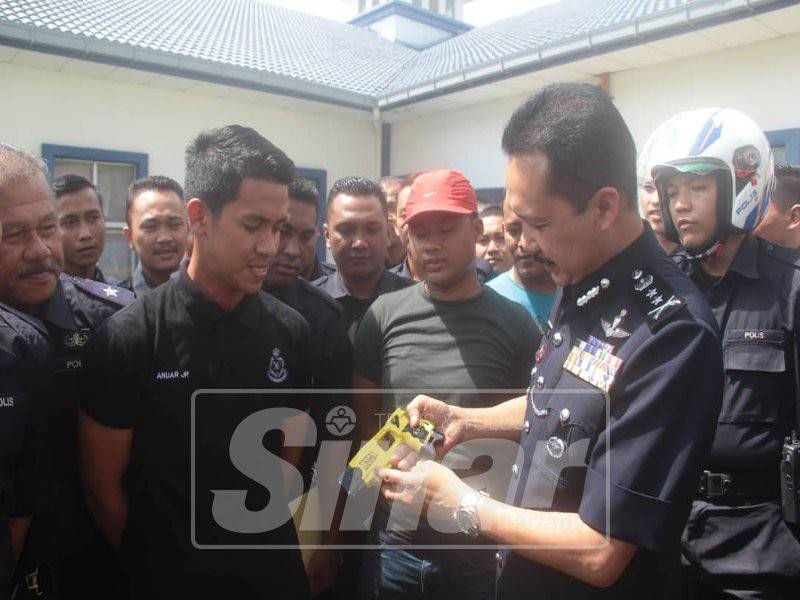 Mohd Yusri memberi penerangan penggunaan pistol pegun kepada para peserta pada Majlis Penutup Kursus Pengendalian Pistol Pegun Siri 2/2018 di Kompleks Logistik Polis Diraja Malaysia (PDRM) di sini, hari ini.