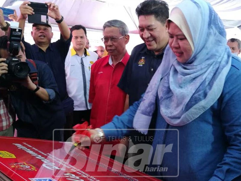 Rina diiringi Sazmi (dua, kiri) dan Mustapa (kiri) menandatangani plak sebagai simbolik perasmian.