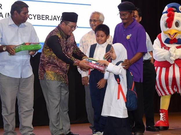 Menteri Besar Selangor Amirudin Shari (dua, kiri) menyampaikan sumbangan peralatan sekolah kepada penerima ketika majlis Program Agihan Perdana Bantuan Pendidikan Asnaf Fakir dan Miskin Lembaga Zakat Selangor Sesi 2018 hari ini. Foto: Bernama 