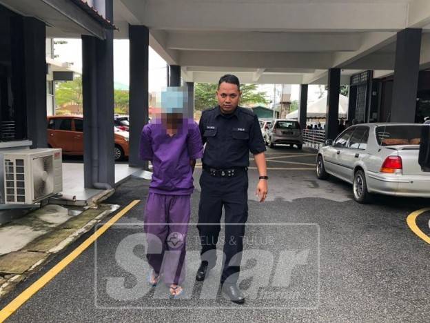 Tertuduh (kiri) dikawal ketat polis keluar dari mahkamah selepas dihukum.