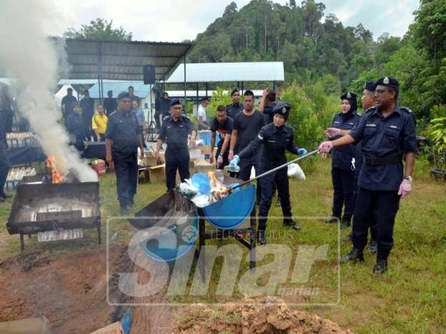 Allaudeen ( kanan) melupuskan dadah yang telah selesai dibicarakan itu.