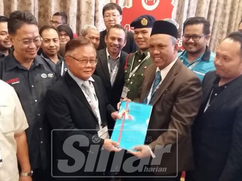 Ishak (dua, kanan) menyerahkan resolusi Persidangan dan Pameran Malaysian Water Engineers Action Committee kali ke-31 kepada Noor Azahari, semalam.