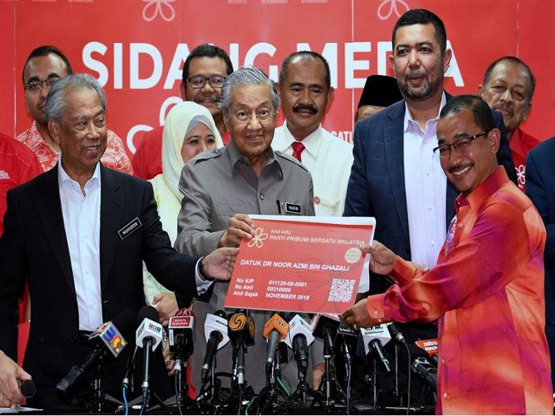 Mahathir (tengah) menerima borang keahlian Noor Azmi bagi menyertai PPBM ketika sidang media selepas mempengerusikan Majlis Pimpinan Tertinggi Bersatu di Menara Yayasan Selangor malam ini. - Foto Bernama