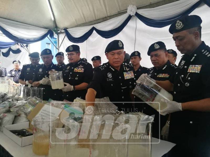 Mohamad (tiga, kanan) menunjukkan rampasan dadah serta peralatan memproses dalam serbuan di sekitar Lembah Klang, Selasa lalu.