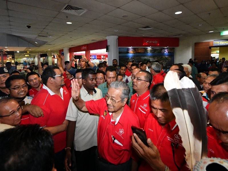 Perdana Menteri Tun Dr Mahathir Mohamad disambut oleh para penyokong sebaik tiba di Lapangan Terbang Bintulu malam ini. - Foto Bernama