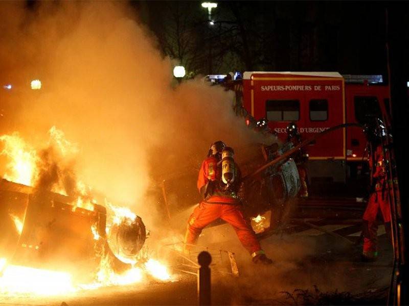 Anggota bomba memadam kenderaan yang dibakar perusuh 'ves kuning'. - Foto Reuters